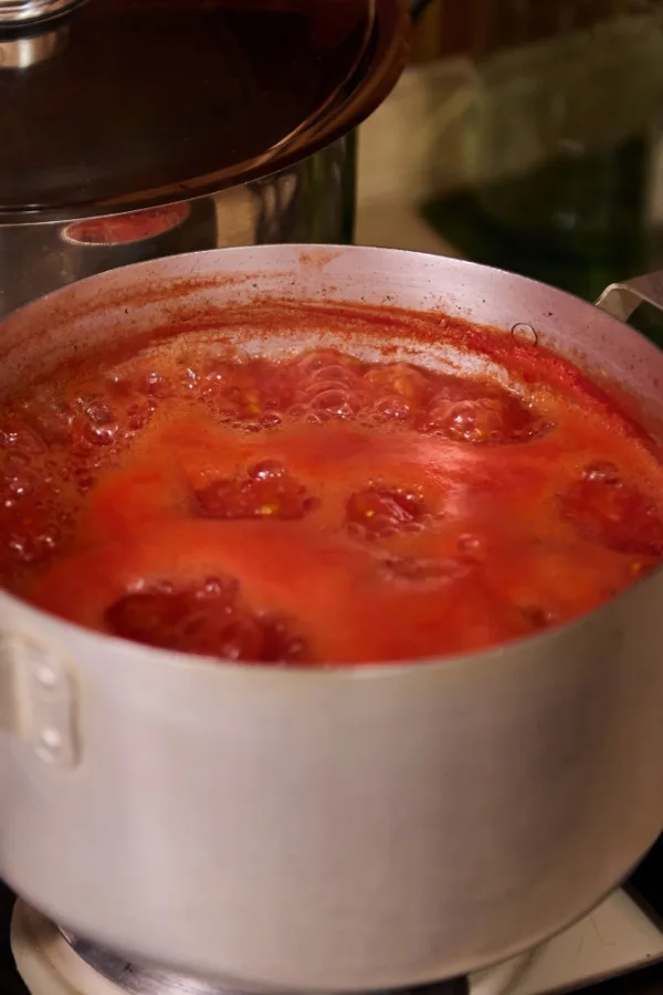 A big pot of tomatoes cooking down on a stove.