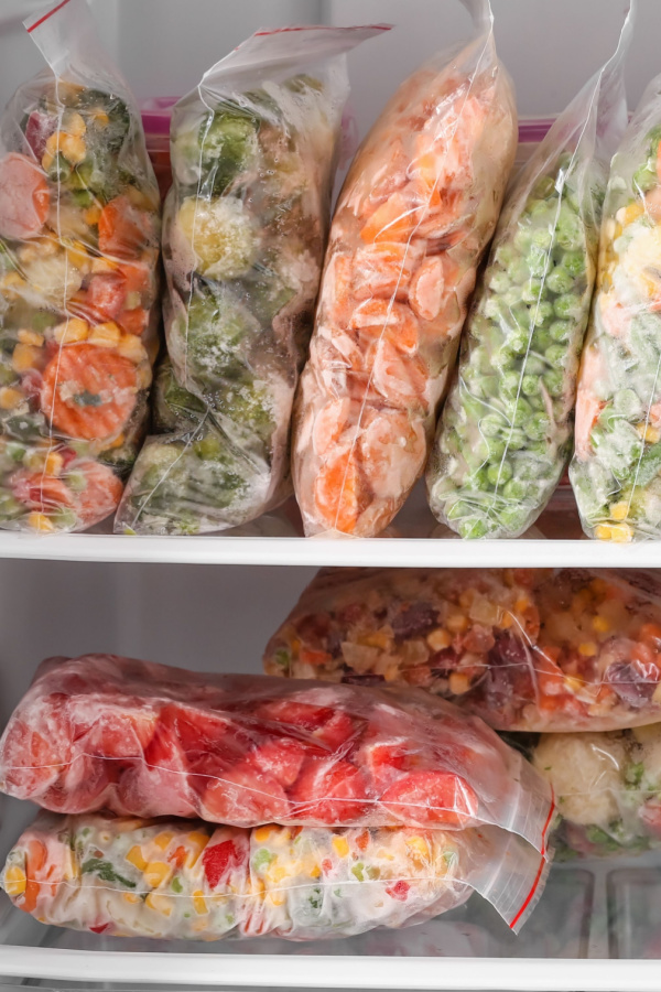 Several different vegetables stacked  in freezer bags.