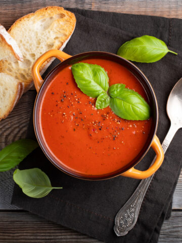 bowl of homemade tomato soup with 2 pieces of bread