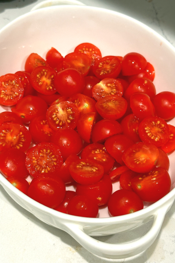 sliced cherry tomatoes in a baking dish 