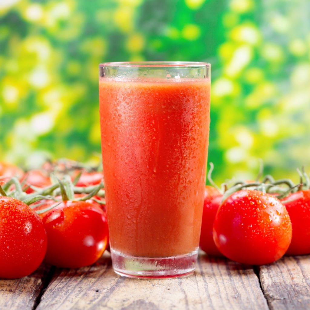 A glass of tomato juice and tomatoes