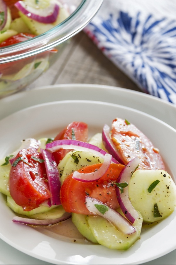 cucumber onion tomato salad on white plate