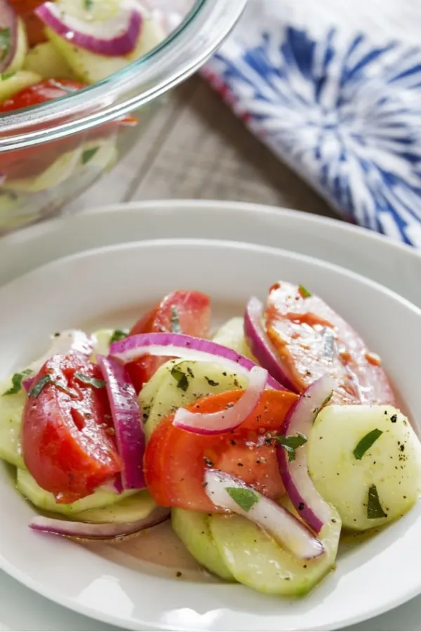 cucumber onion tomato salad on white plate